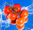 five fresh tomatoes in water splash