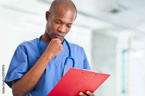 Foto: Black doctor reading a clipboard Black doctor reading a clipboard