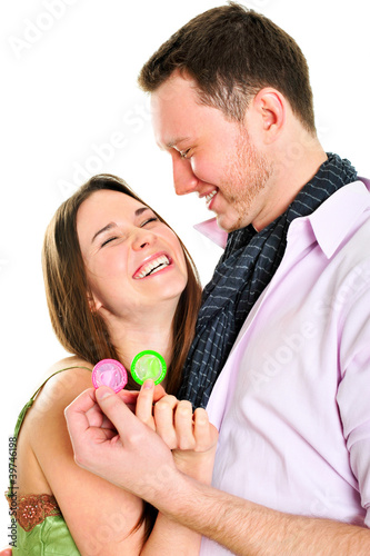 Photo: Young couple embracing and holding condoms Young couple embracing and holding condoms