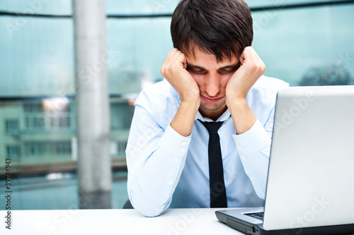 Photo: Tired businessman sleeping at his desk in the office Tired businessman sleeping at his desk in the office