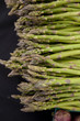 Freshly harvested organic asparagus spears with purple artichoke