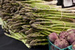 Freshly harvested organic asparagus spears with purple artichoke