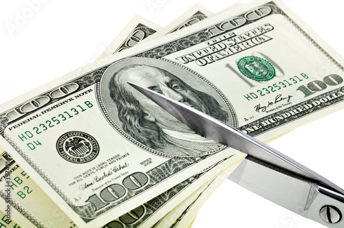 Photo: Business concept. Dollars are cutting with scissors. Business concept. Dollars are cutting with scissors.