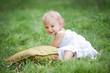 baby sitting on green grass