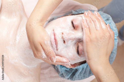 Photo: Beautiful woman with facial mask getting beauty treatment at sal Beautiful woman with facial mask getting beauty treatment at sal