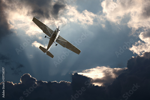 Photo: Small fixed wing plane against a stormy sky Small fixed wing plane against a stormy sky