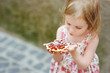 Little girl eating a strawberry tart