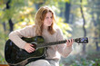 Photo: Young beautiful girl playing guitar, selective focus Young beautiful girl playing guitar, selective focus
