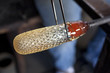 Glass blower shaping molten glass