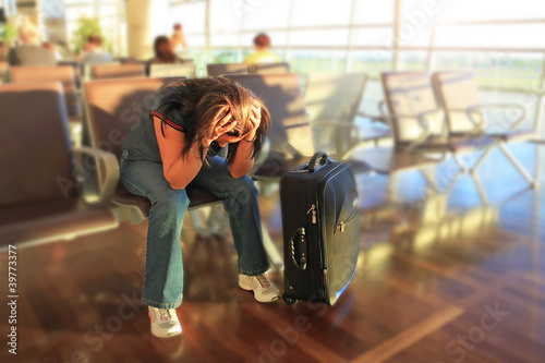 Foto: Depressed woman awaiting for plane with delay Depressed woman awaiting for plane with delay