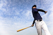 baseball player taking a swing with cloud background