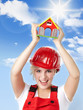 Happy young female worker in overall presents a toy house