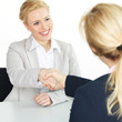 Young woman in an interview shaking hands with her new boss