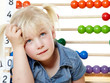 Foto: Cute blonde girl thinking about difficult math homework Cute blonde girl thinking about difficult math homework