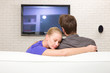 Foto: man watching tv woman embraces him man watching tv woman embraces him