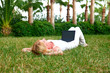 Young beautiful woman working with laptop in the green grass