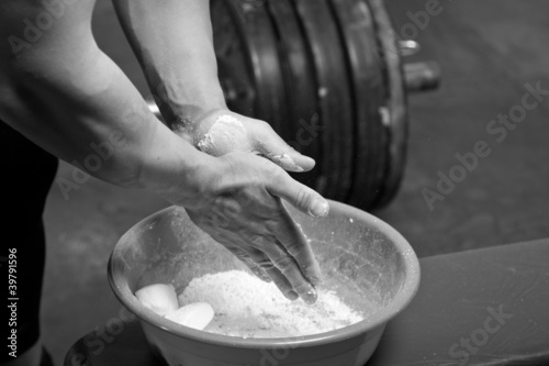Photo: Closeup of hands of the weightlifter in talc Closeup of hands of the weightlifter in talc