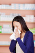 junge frau mit allergie in der apotheke