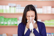 frau mit allergie in der apotheke