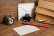 Antique clock, postcard, envelope, ink pen and inkwell on wood