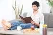 man relaxed in sofa with album at breakfast time