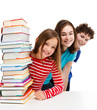 Students peeking behind pile of books on white