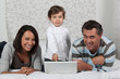Parents and daughter on bed with computer