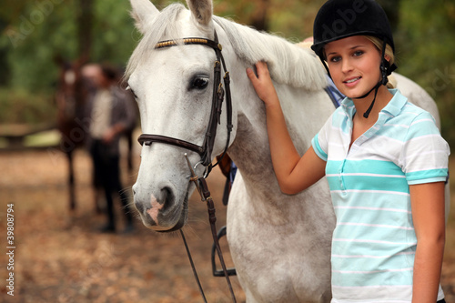 Photo: Blond teenager next to horse Blond teenager next to horse