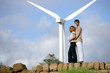 Couple standing before a wind turbine