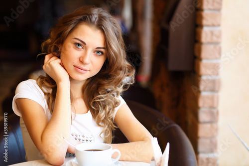 Photo: Young pretty woman sitting in restaurant Young pretty woman sitting in restaurant