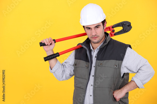 Photo: Tradesman carrying a pair of large clippers on his shoulder Tradesman carrying a pair of large clippers on his shoulder