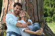 Couple sitting against a tree