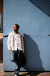 Young man leaning against a city wall