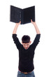 Angry teenage boy throwing laptop isolated on white