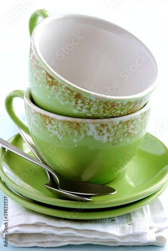 Photo: green cup, saucer and spoon on a napkin green cup, saucer and spoon on a napkin