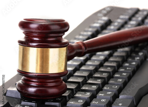 Photo: wooden gavel on keyboard isolated on white wooden gavel on keyboard isolated on white