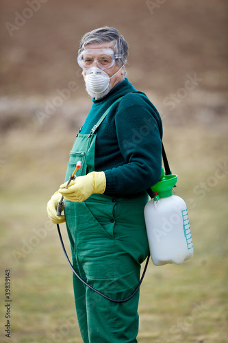 Photo: gardener applying an insecticide/a fertilizer to his fruit gardener applying an insecticide/a fertilizer to his fruit