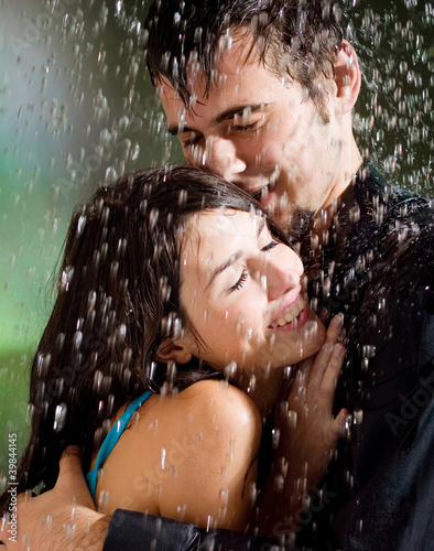 Photo: Young couple hugging under a rain Young couple hugging under a rain