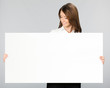 Businesswoman showing signboard, over grey