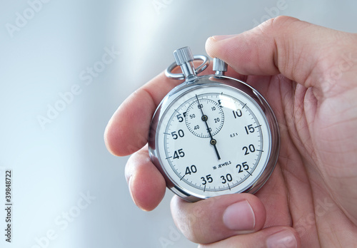 Photo: Human hand holding stopwatch Human hand holding stopwatch