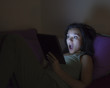 Young woman reading a tablet in the dark