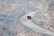 Photo: Massive dump truck moving downhill on whide and steep road Massive dump truck moving downhill on whide and steep road