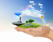 Human hand holding a green landscape