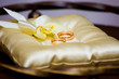 Gold wedding rings on a gold pillow