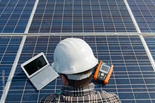 Photo: Man testing a photovoltaic plant with laptop Man testing a photovoltaic plant with laptop
