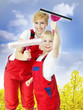 Sisters in overalls clean windows for spring cleaning
