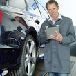 Master mechanic in a garage working with touchpad