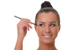 Charming young woman applying blusher eyelid close up