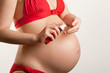 Skin care in pregnancy: young pregnant woman with body cream