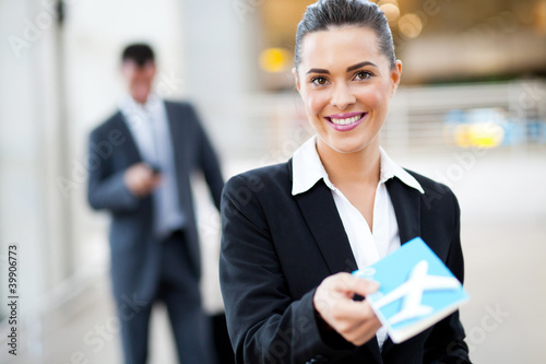 Photo: attractive businesswoman handing over air ticket at airport attractive businesswoman handing over air ticket at airport
